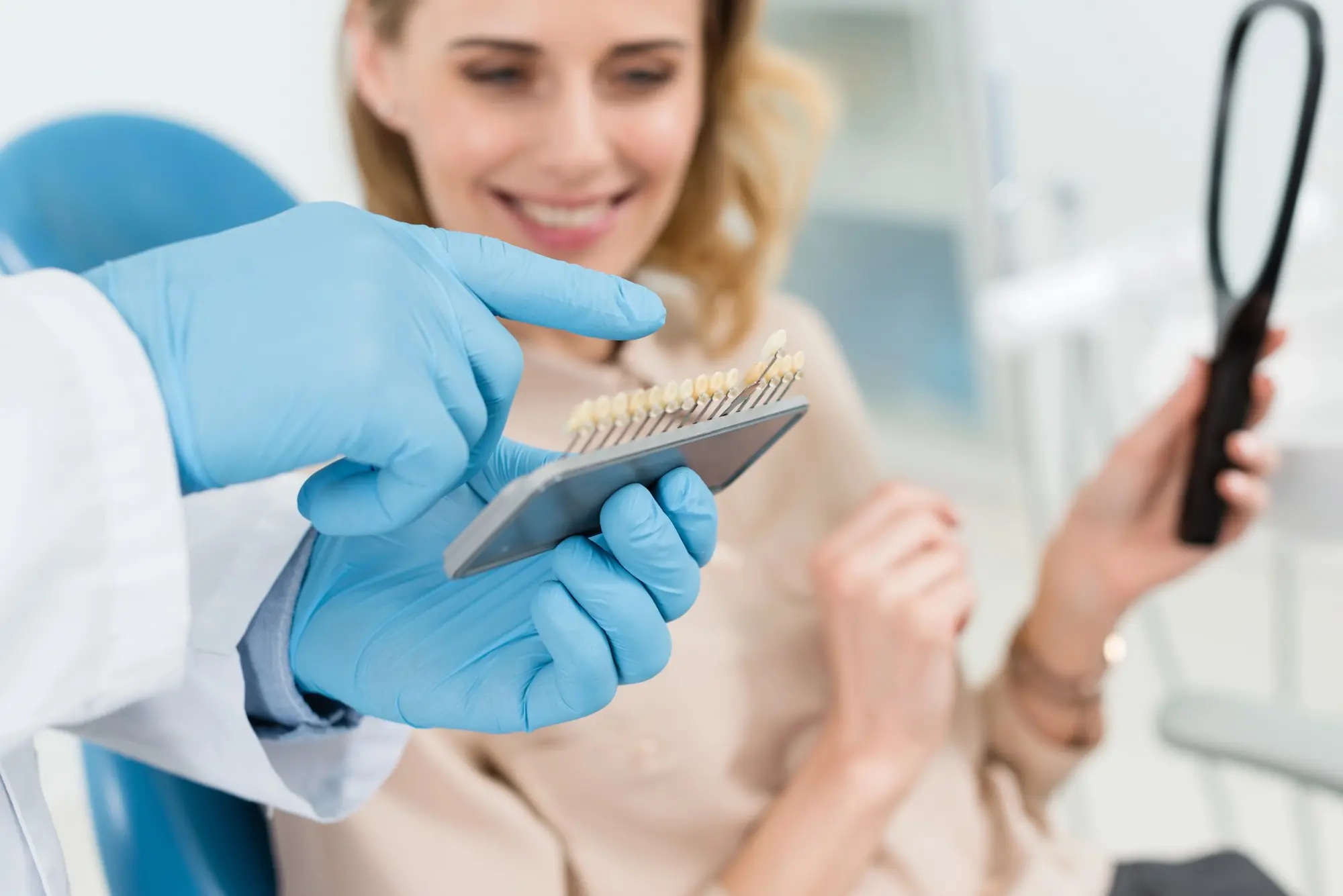 A dentist showing a woman a teeth colour palette