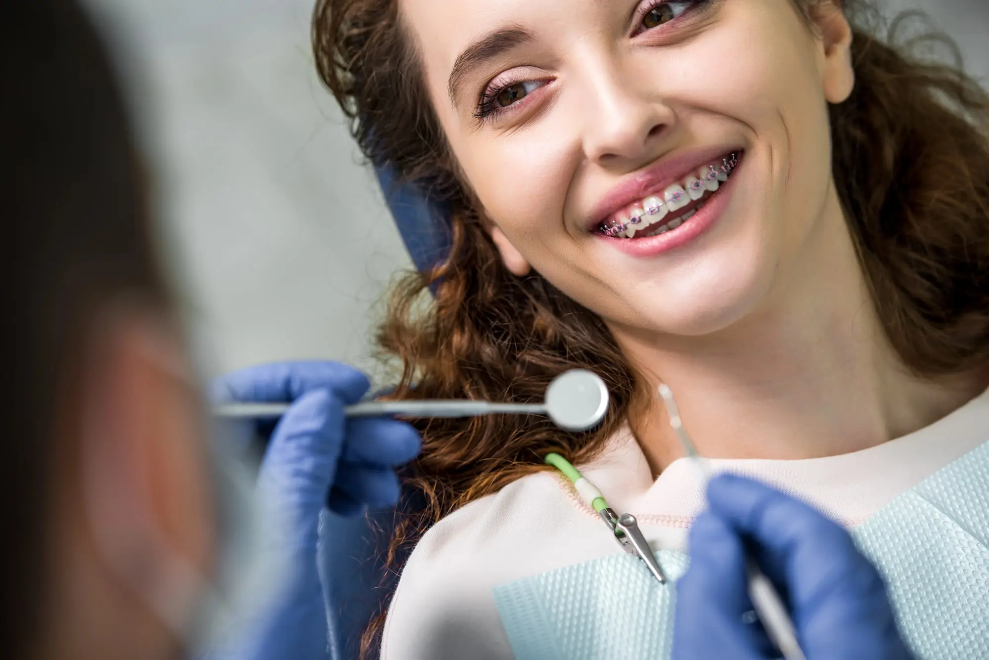 Smiling woman at the dentist getting her braces checked