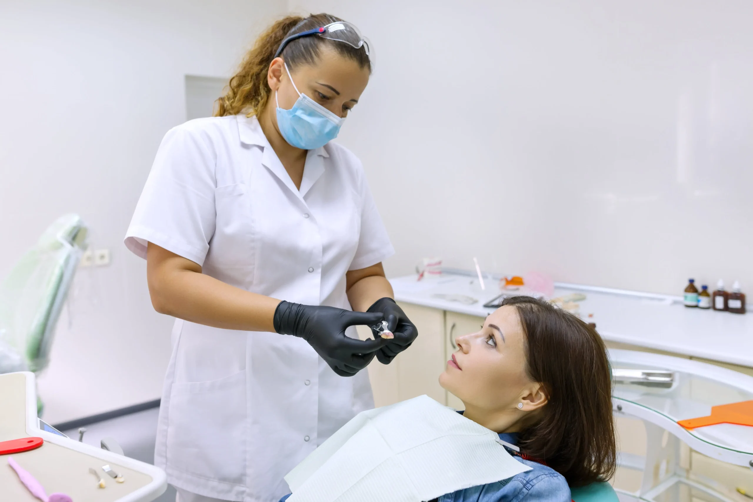 A woman on a dental chair while a dentist explains a procedure to her